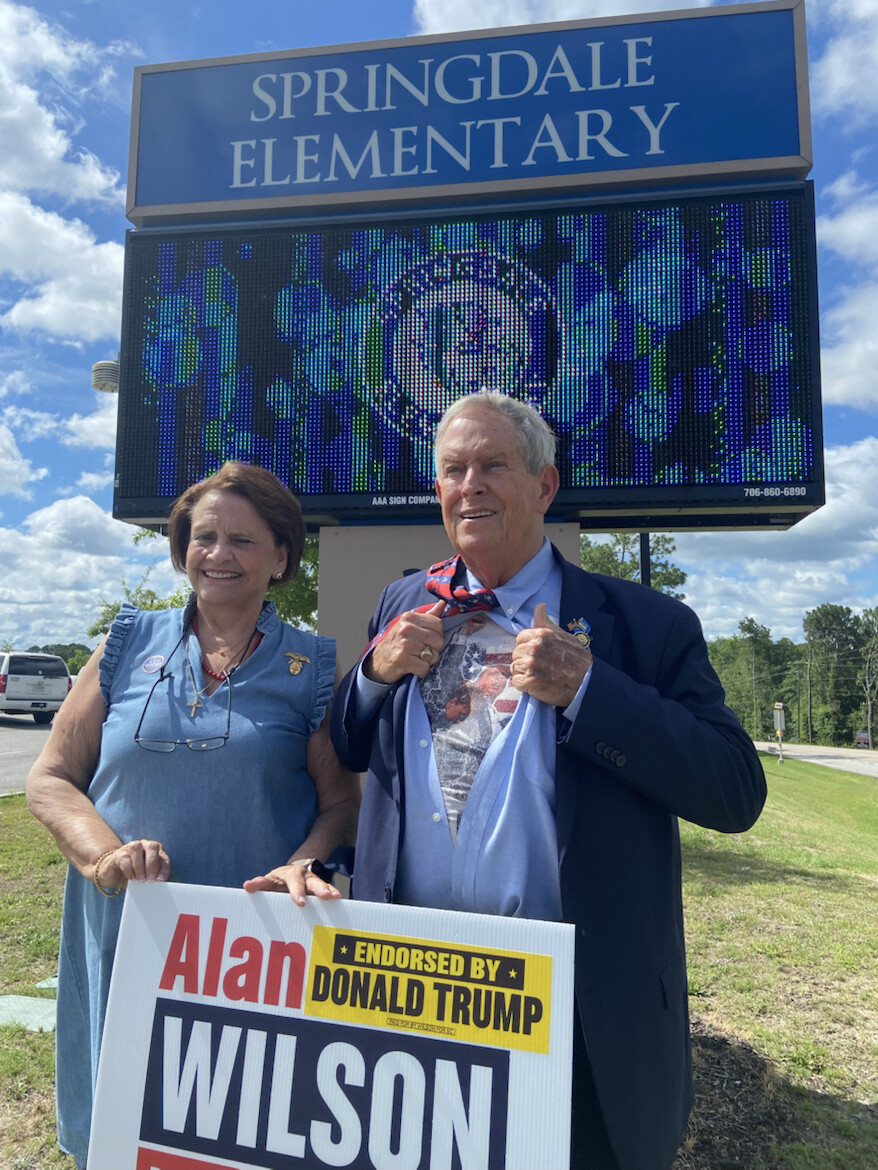 A campaign sign for Alan Wilson, endorsed by Donald J. Trump, is held by an unidentified man at Springdale Elementary on 07/11/2026.